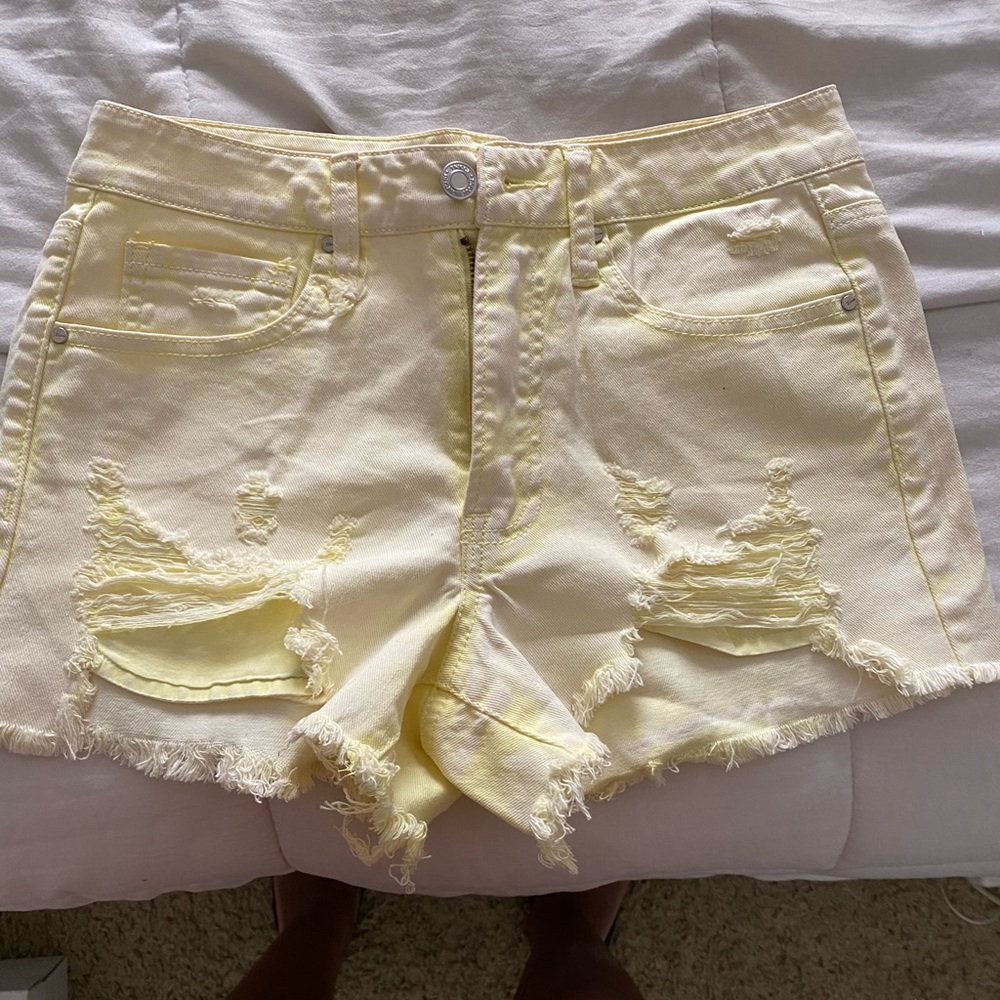 Small, yellow, distressed denim shorts.